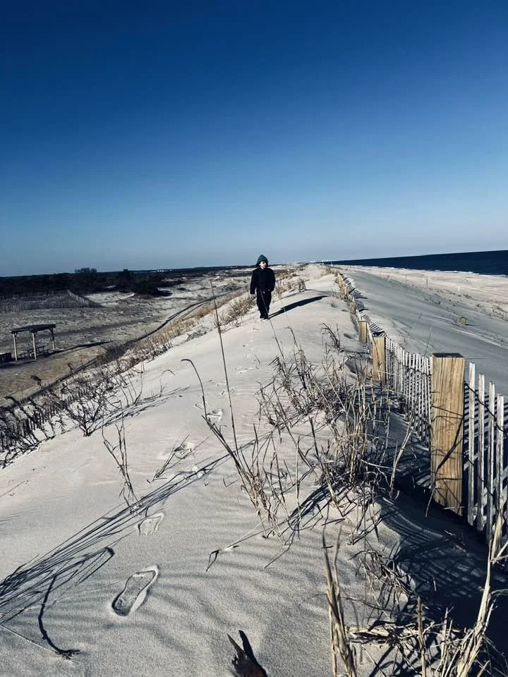 A child walking on the dunes by the sea